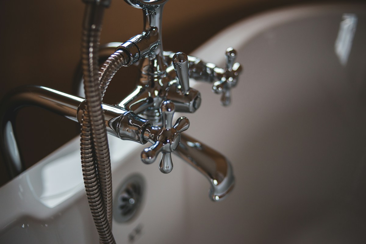 Close-up of a shower fixture and its plumbing